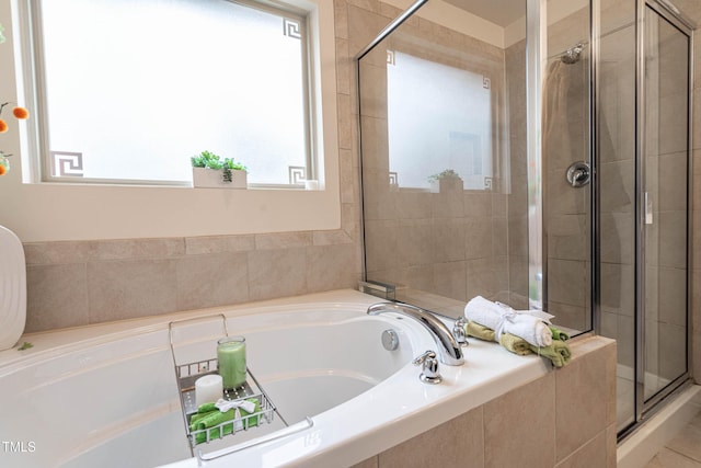 bathroom featuring a stall shower and a bath