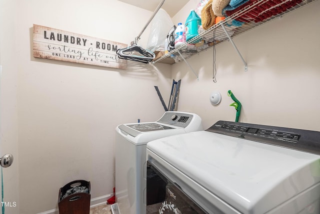 washroom featuring baseboards, laundry area, and washer and dryer