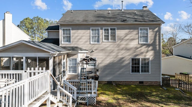 back of property featuring fence, a sunroom, a yard, stairway, and crawl space