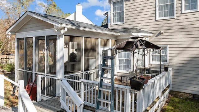 view of property exterior with a sunroom and a chimney