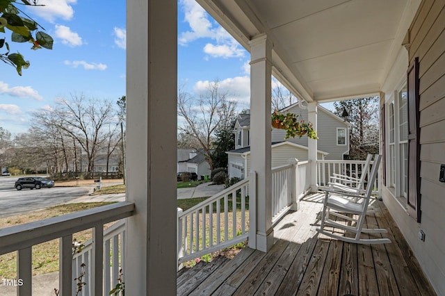 deck with covered porch and a residential view