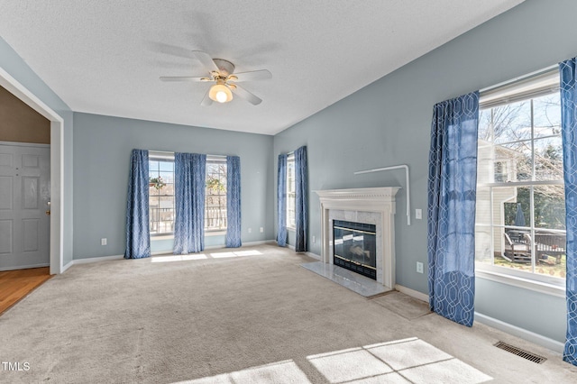 unfurnished living room featuring carpet flooring, a high end fireplace, visible vents, and baseboards