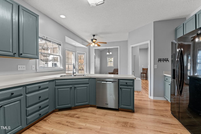 kitchen with a peninsula, a sink, black fridge with ice dispenser, light wood-type flooring, and dishwasher