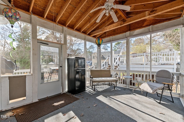 sunroom / solarium with a ceiling fan and vaulted ceiling