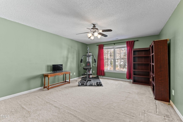 workout area with carpet floors, ceiling fan, baseboards, and a textured ceiling