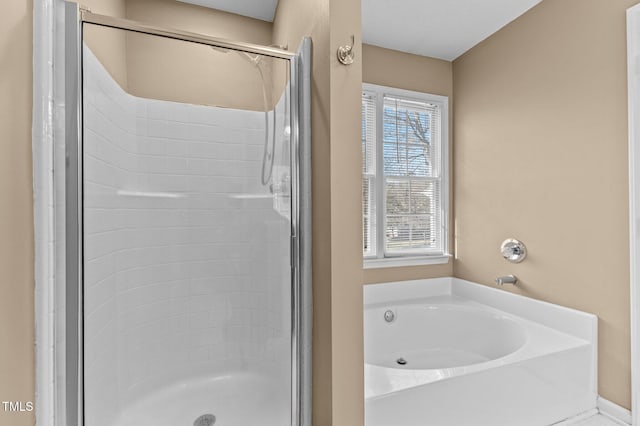 bathroom with a shower stall and a bath