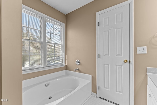 full bathroom featuring vanity, baseboards, and a bath