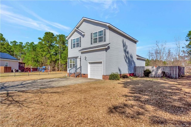 back of property featuring driveway, crawl space, a garage, and fence