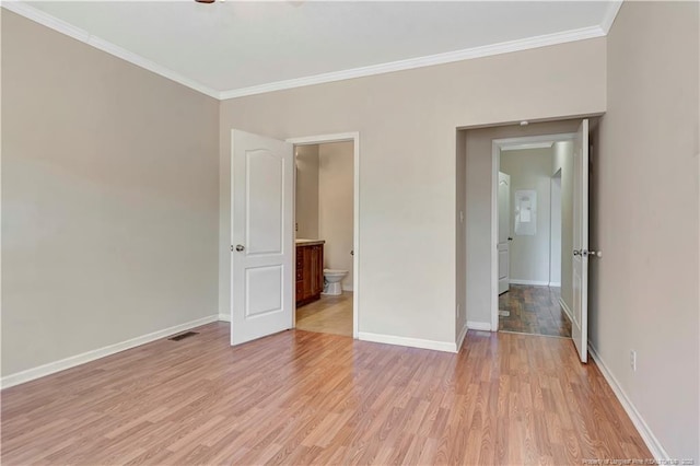 unfurnished bedroom with visible vents, baseboards, ensuite bath, light wood-style flooring, and ornamental molding