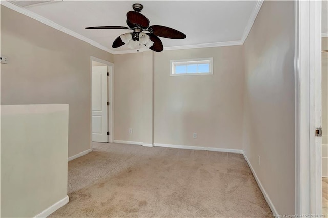 empty room with carpet, baseboards, ceiling fan, and crown molding