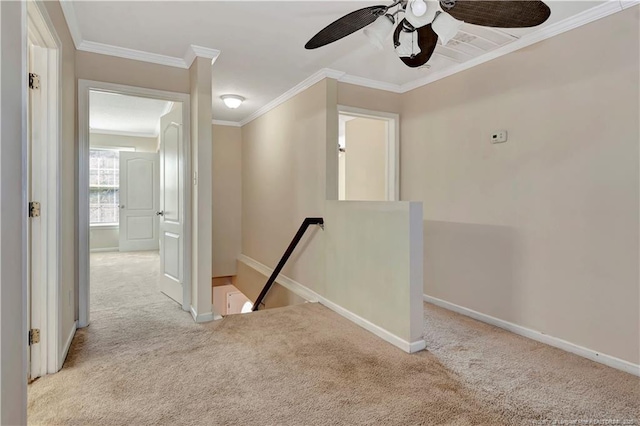 hallway featuring baseboards, carpet flooring, an upstairs landing, and crown molding