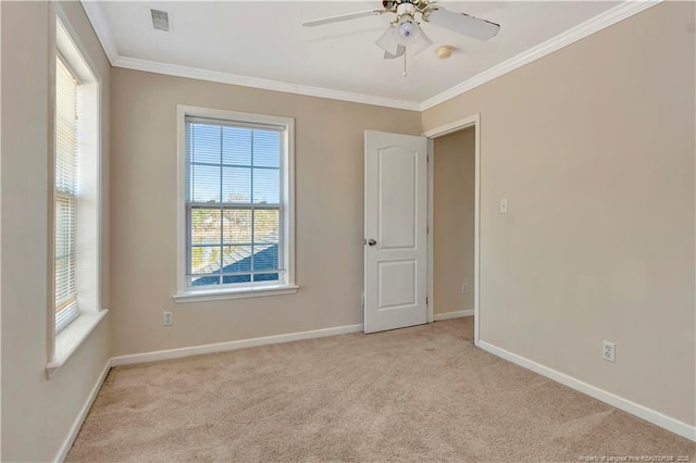 carpeted spare room featuring visible vents, ornamental molding, ceiling fan, and baseboards