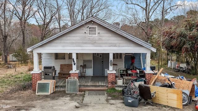 bungalow-style home with a porch and a chimney