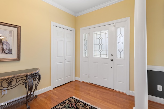 foyer entrance featuring ornamental molding, light wood-type flooring, and baseboards