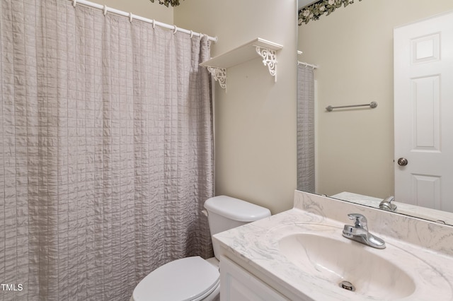 bathroom with curtained shower, vanity, and toilet