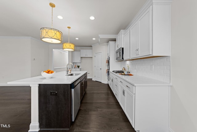 kitchen with dark wood-style floors, ornamental molding, decorative backsplash, white cabinets, and appliances with stainless steel finishes