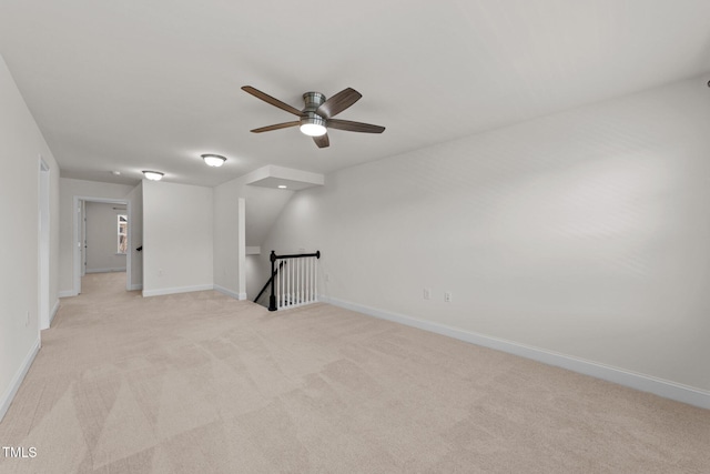 unfurnished room with baseboards, light carpet, and a ceiling fan