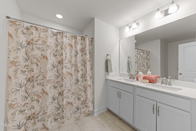 bathroom featuring tile patterned flooring, double vanity, curtained shower, and a sink