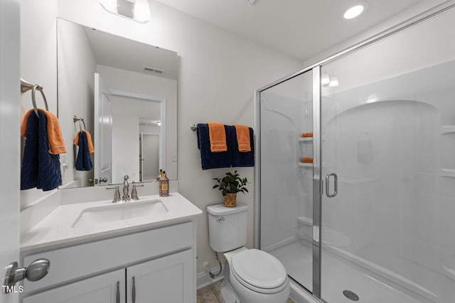 full bathroom featuring vanity, a shower stall, toilet, and visible vents