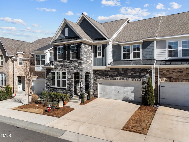 view of front of home with stone siding, an attached garage, driveway, and a standing seam roof