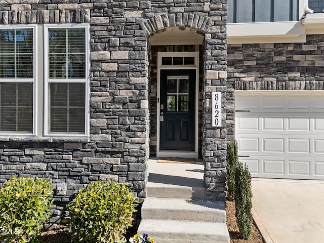 entrance to property with stone siding and a garage