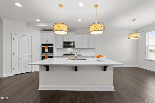 kitchen with a sink, appliances with stainless steel finishes, light countertops, and ornamental molding