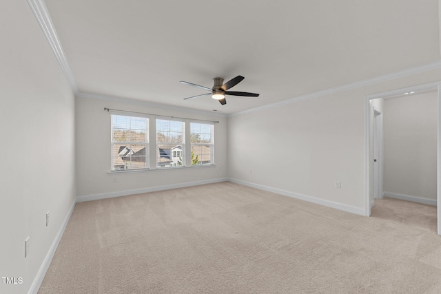 empty room featuring crown molding, baseboards, and light carpet