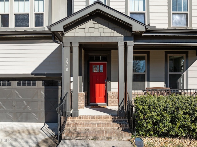 entrance to property with brick siding, a porch, and concrete driveway