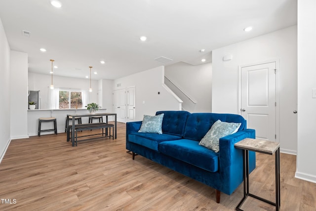 living room with baseboards, wood finished floors, visible vents, and recessed lighting