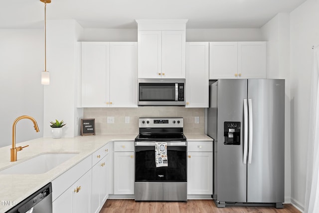 kitchen featuring white cabinets, tasteful backsplash, stainless steel appliances, and a sink