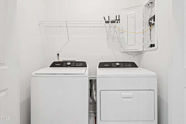 clothes washing area with electric panel and washer and dryer