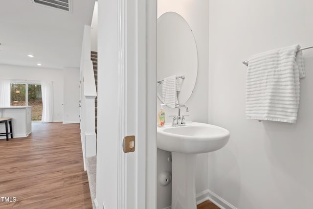 bathroom featuring baseboards, visible vents, wood finished floors, and recessed lighting