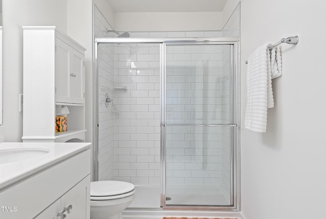 full bath with a stall shower, vanity, and toilet