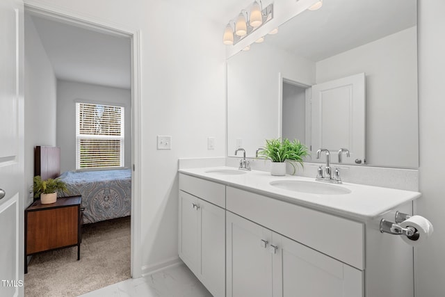 full bath featuring connected bathroom, marble finish floor, a sink, and double vanity