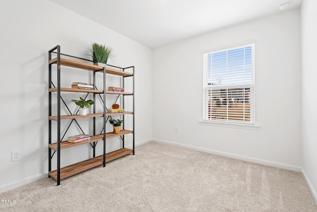 carpeted empty room featuring baseboards