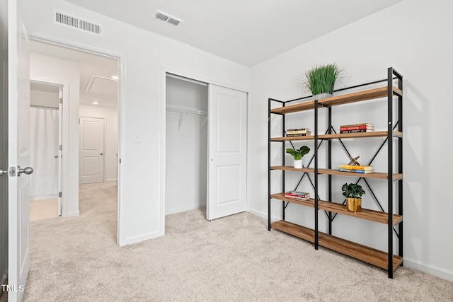 carpeted bedroom featuring baseboards, a closet, visible vents, and attic access