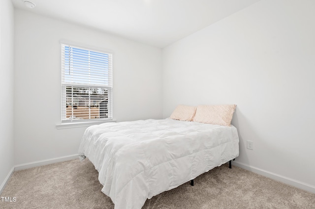 carpeted bedroom featuring baseboards