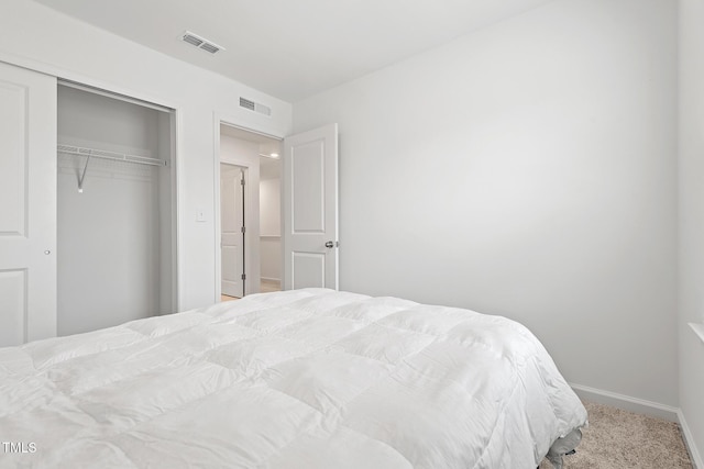 bedroom with carpet floors, baseboards, visible vents, and a closet