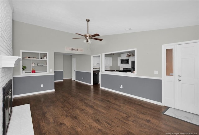 unfurnished living room with lofted ceiling, wood finished floors, a ceiling fan, baseboards, and a brick fireplace