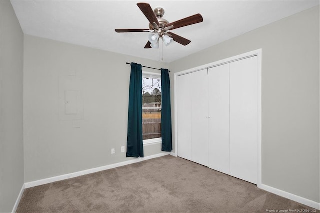 unfurnished bedroom featuring ceiling fan, a closet, baseboards, and carpet flooring