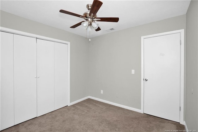 unfurnished bedroom featuring baseboards, visible vents, a ceiling fan, carpet floors, and a closet