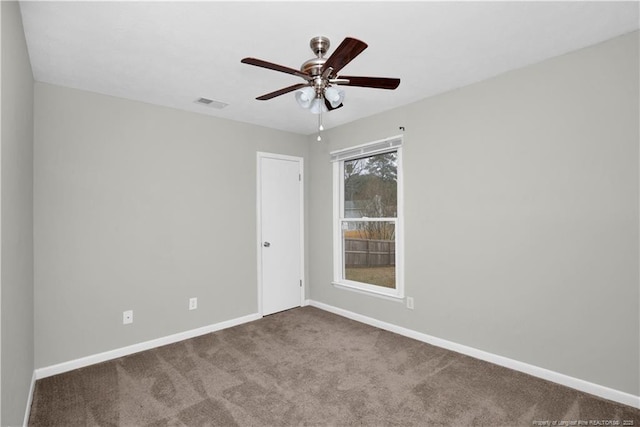 carpeted empty room with a ceiling fan, visible vents, and baseboards