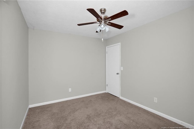 empty room featuring carpet, a ceiling fan, and baseboards