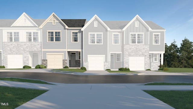 townhome / multi-family property with a garage, stone siding, and board and batten siding