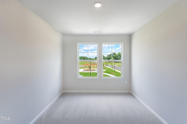 empty room featuring light carpet, baseboards, and visible vents