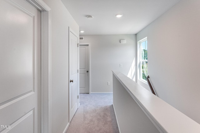 corridor featuring light carpet, recessed lighting, visible vents, and baseboards