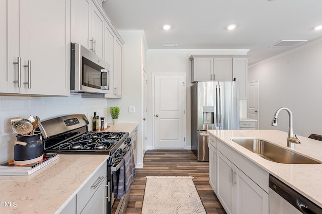 kitchen with a sink, appliances with stainless steel finishes, backsplash, dark wood finished floors, and crown molding