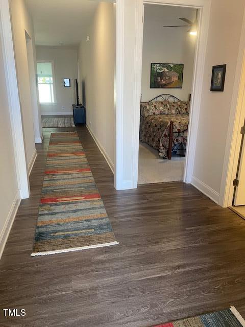 hall with baseboards and wood finished floors