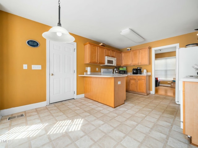 kitchen featuring white microwave, a peninsula, baseboards, light countertops, and light floors