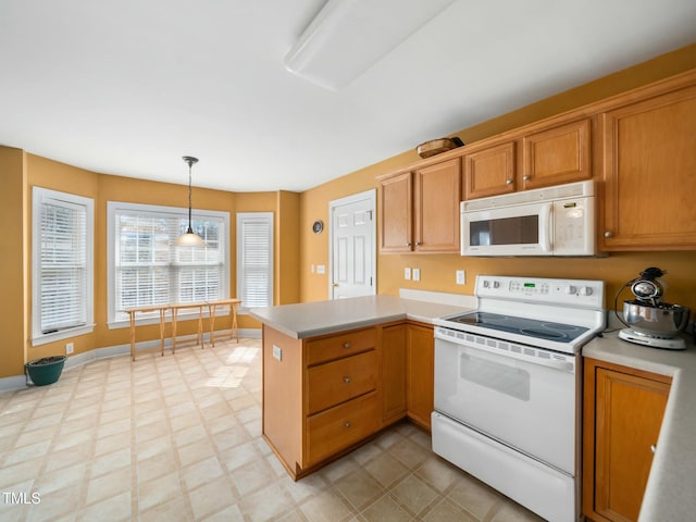 kitchen featuring a peninsula, white appliances, pendant lighting, and light countertops